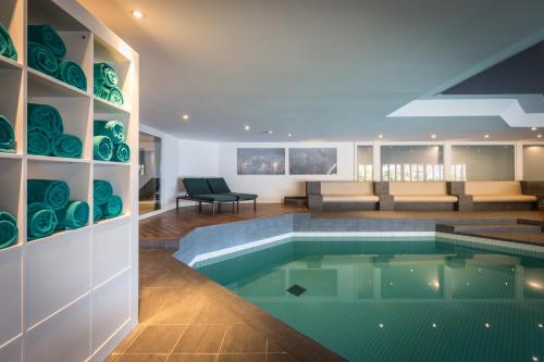 a swimming pool in a house with a living room at HUUS Gstaad in Gstaad