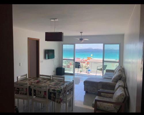 un salon avec un canapé et une table dans l'établissement Apt frente para o mar - Prainha, Arraial do Cabo, à Rio de Janeiro