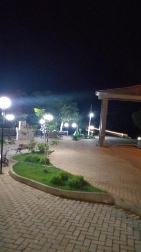 einen Park in der Nacht mit Straßenbeleuchtung und einem Pavillon in der Unterkunft Pousada Serra Da Canastra in Vargem Bonita