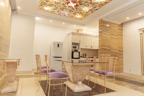 ein Esszimmer mit einem Tisch und Stühlen sowie eine Küche in der Unterkunft SULO Apartments in Atyrau