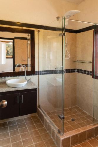 a bathroom with a glass shower and a sink at hotel villa claudia in Nobsa