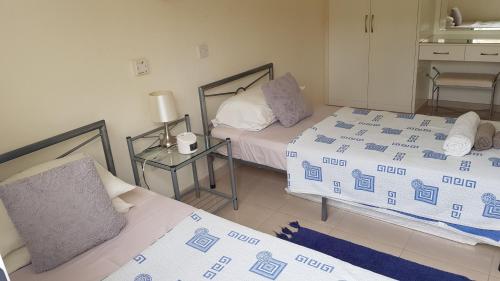 Cette chambre comprend 2 lits et une chaise. dans l'établissement Dahan Sirena lighthouse Luxury Apartment, à Paphos