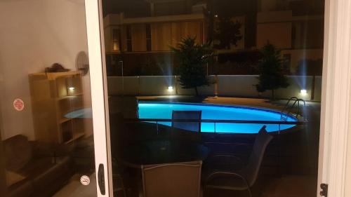 a swimming pool with a table and chairs in a room at Dahan Sirena lighthouse Luxury Apartment in Paphos