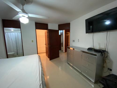 a living room with a bed and a tv on the wall at Santo Domingo Paradise V - #211 in La Estrella