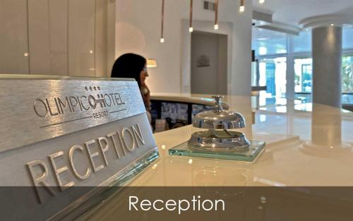 a sign on a counter with a reporiaoria reception at Hotel Olimpico in Pontecagnano