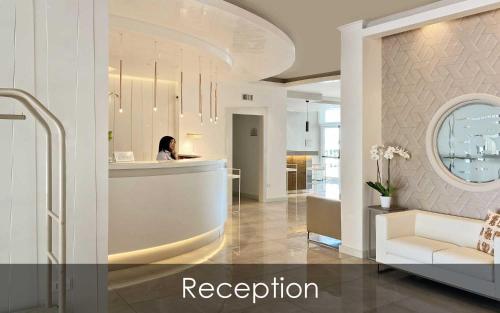 a woman sitting at a reception desk in a lobby at Hotel Olimpico in Pontecagnano