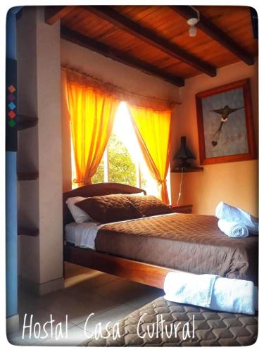 a bedroom with two beds and a window at Casa Cultural Mindo in Mindo