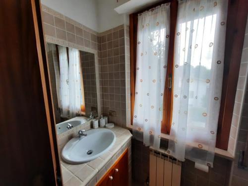 ein Bad mit einem Waschbecken und einem Spiegel in der Unterkunft Appartamento VACANZE DI PUCCI LIDIA in Assisi