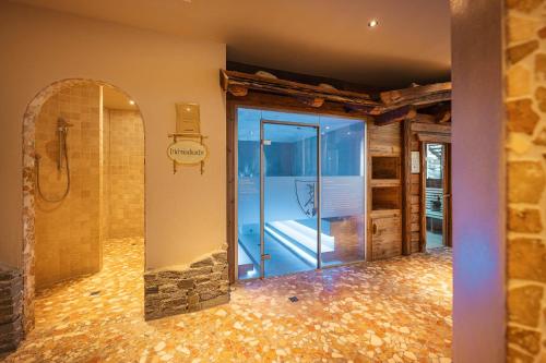 a bathroom with a glass door and a mirror at Premium Activehotel Bergkönig in Neustift im Stubaital