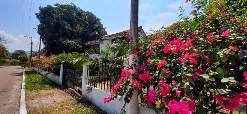 a fence with pink flowers on the side of a house at Casa Campestre Villa Margarita in Honda