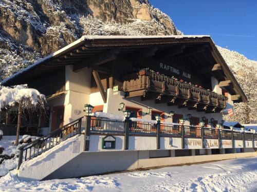 a building with a balcony in the snow at Gasthof Rafting Alm in Haiming