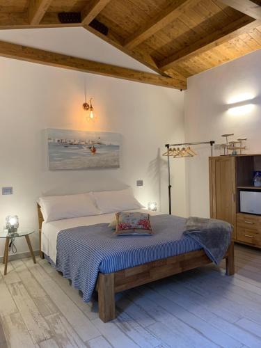 una camera con un grande letto in una stanza con soffitti in legno di Rosamare a Cesenatico