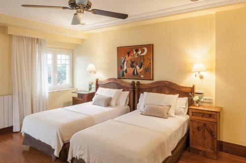 聖塞巴斯提安的住宿－拉格瑞酒店，一间卧室配有两张床和吊扇
