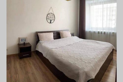 um quarto com uma cama grande e uma janela em Apartamentai Draugystes Street em Siauliai