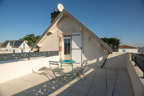 a table and chairs on the roof of a house at Gite LES BALISES- BABORD-Maisons de bord de mer avec spa -SAINT GILLES CROIX DE VIE - 27 Avenue NOTRE DAME in Saint-Gilles-Croix-de-Vie