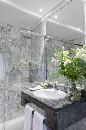 a bathroom with a sink and a vase of flowers at La Galería in San Sebastián