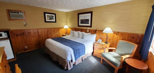 a hotel room with a bed and a chair at The Lake Motel in Lake George
