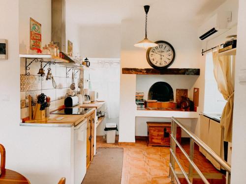 eine Küche mit einer Uhr an der Wand und einer Theke in der Unterkunft Granny's farm in São Vicente
