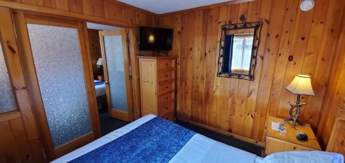 a bedroom with a bed and a mirror and a window at The Lake Motel in Lake George