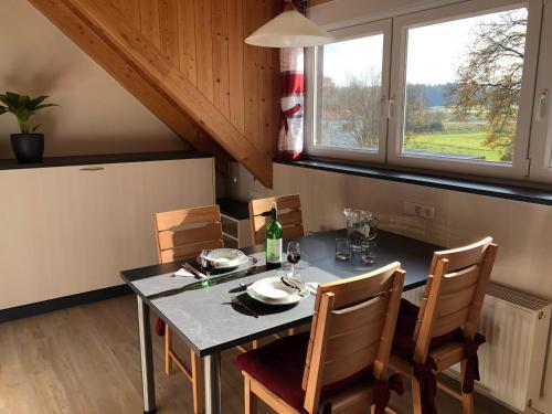 comedor con mesa, sillas y ventana en Ferienwohnung Zückner, Fränkisches Seenland, en Georgensgmünd