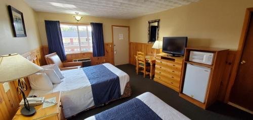 a hotel room with a bed and a television at The Lake Motel in Lake George