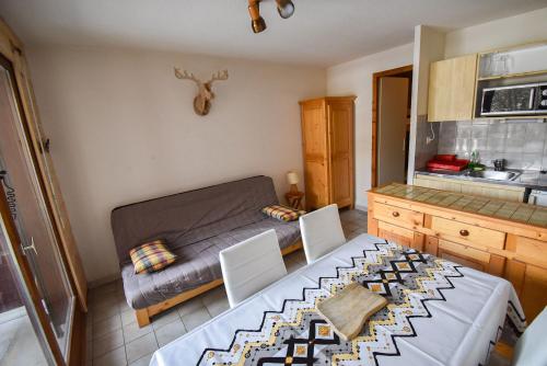 a small room with a bed and a table and chairs at Le Pied des Pistes A13, Joli Studio tout confort 4 pers, vue vallée imprenable, DRAPS NON COMPRIS in Saint-Jean-d'Aulps