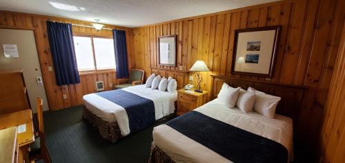 a hotel room with two beds and wooden walls at The Lake Motel in Lake George