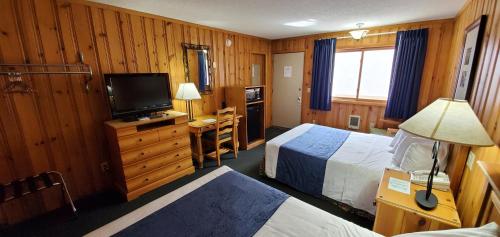 a hotel room with two beds and a television at The Lake Motel in Lake George