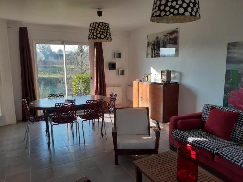 un salon avec une table et des chaises dans l'établissement Gites Nature & Espace - Le puits des souhaits, à Villedieu-les-Poêles