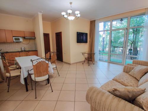 a living room with a couch and a table and chairs at Заміський комплекс "Пуща Лісна" in Moshchun
