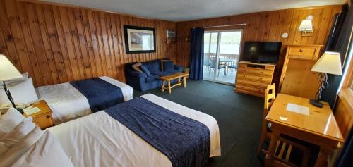 a hotel room with two beds and a television at The Lake Motel in Lake George