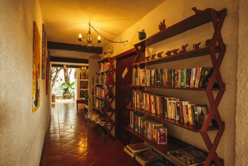 a hallway with book shelves filled with books at Las Mariposas Hotel & Studios in Oaxaca City