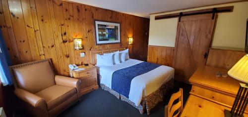 a hotel room with a bed and a chair at The Lake Motel in Lake George