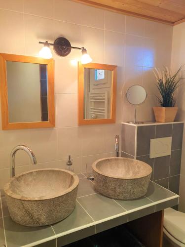two sinks sitting on a counter in a bathroom at Chalet le Petit Ramoneur in Châtel