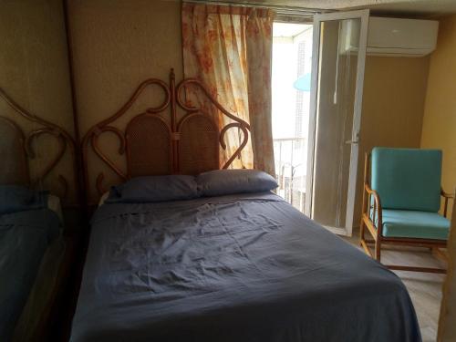 a bedroom with a bed and a chair and a window at IOW4 LM Junior Suite in Acapulco