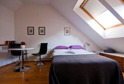 a bedroom with a bed with purple pillows and a window at Old Town Riga in Rīga
