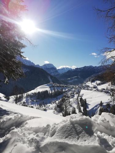 a snow covered mountain with the sun in the background at Cesa de Conesel in Colle Santa Lucia