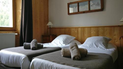 two beds in a hotel room with towels on them at Hôtel Bellier in Val dʼIsère