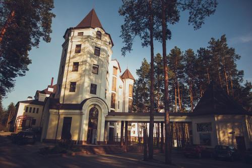 a large white building with a tower at Заміський комплекс "Пуща Лісна" in Moshchun