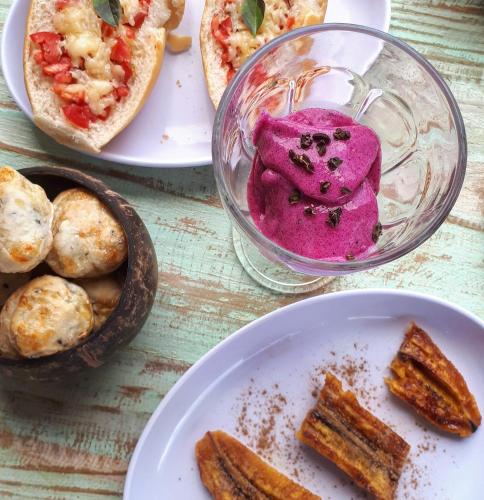 a table with plates of food and a plate of bread at Pousada Vila Cacau in Serra Grande