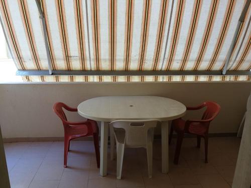 - une table et des chaises dans une chambre avec fenêtre dans l'établissement Gallipoli lido San giovanni, à Gallipoli