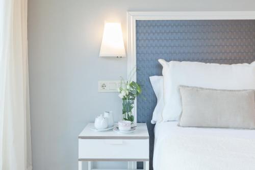 a bedroom with a bed and a side table with a lamp at Hotel Monte Ulia in Donostia-San Sebastián