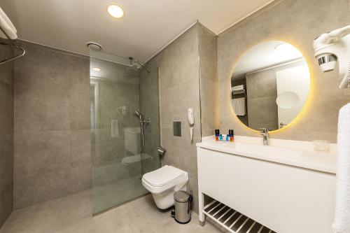 a bathroom with a toilet and a sink and a mirror at The Halich Hotel Istanbul Karakoy - Special Category in Istanbul