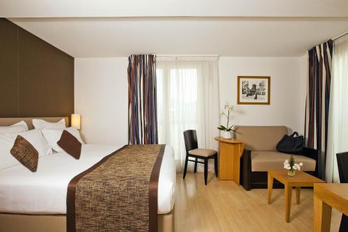 a hotel room with a bed and a couch at Residhome Paris Opéra in Paris