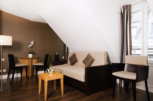 a living room with a couch and chairs and a table at Residhome Paris Opéra in Paris