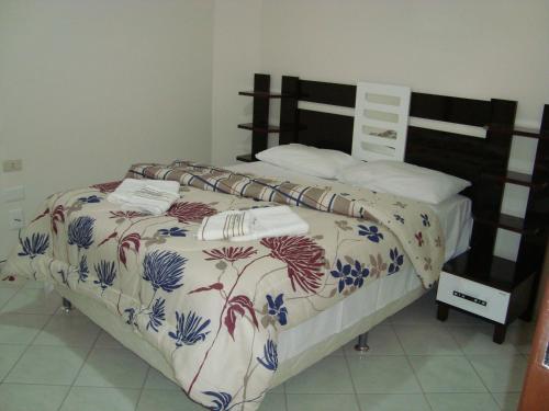 a bedroom with a bed with a floral comforter at Pousada Aguas do Rio Pardo in Cândido Sales