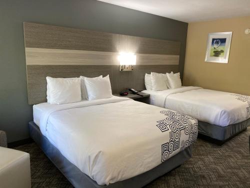 a hotel room with two beds with white sheets at Best Western Apalach Inn in Apalachicola