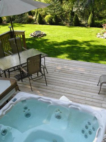 a jacuzzi tub on a wooden deck with a table and a patio at Tucked Inn the Harbour B&B in Victoria Harbour