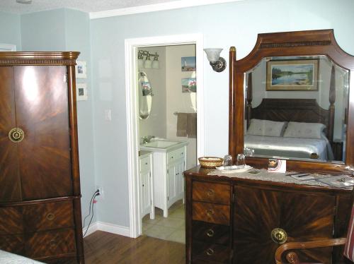 a bedroom with a large mirror and a bed at Tucked Inn the Harbour B&B in Victoria Harbour