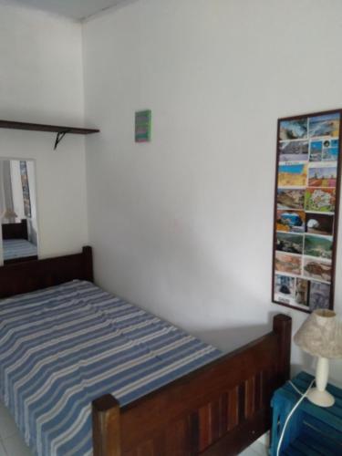 a bedroom with a bed and a blue suitcase at SUITES E CHALES PRIVADOS Rock's&Rose's home in Camburi